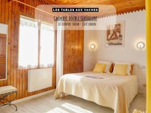 una camera da letto con un letto con pareti in legno e una finestra di Les Tables Aux Vaches à la Salvetat a La Salvetat Altre 30 foto