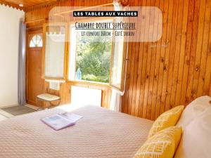 una camera da letto con un letto con un libro sopra di Les Tables Aux Vaches à la Salvetat a La Salvetat