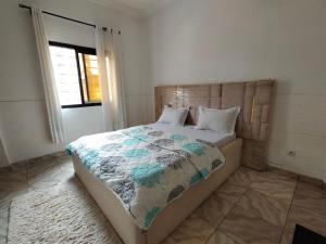 ein Schlafzimmer mit einem Bett mit einer Steppdecke darauf in der Unterkunft Skyland immo in Jaunde