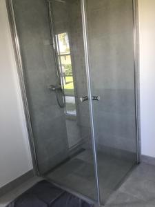 a shower with a glass door in a bathroom at Hyggelig nyrenoveret lejlighed på landet - tæt på Hals og strand in Hals