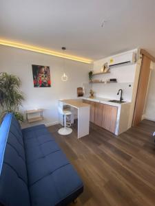 a living room with a blue couch and a kitchen at La Perla Central Sai in San Andrés