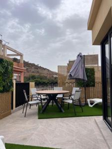 a patio with a table and chairs and an umbrella at Sunny apartment la huerta in Alicante