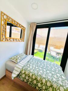 a bedroom with a bed and a large window at Sunny apartment la huerta in Alicante