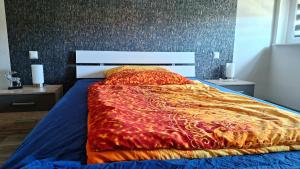 a bedroom with a bed with a red comforter at Pension Bernburg A2 in Bernburg