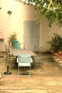 une table et des chaises assises dans la cour dans l'établissement le calme à la campagne, à La Celle-sous-Gouzon