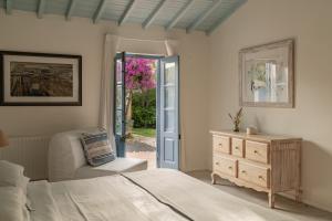 a bedroom with a bed and a dresser and a door at CABRA - Porto Covo in Porto Covo