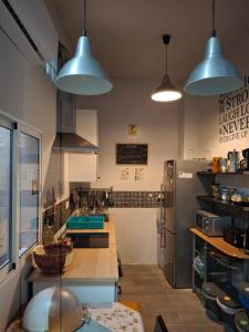 a kitchen with two pendant lights and a refrigerator at La Pita Guesthouse in Almería