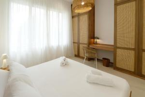 a bedroom with a large white bed and a window at Cálida apartments in Cefalù