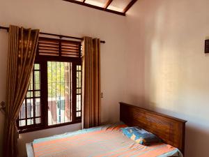 a bedroom with a bed and a window at Madush House in Haburugala