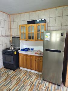 a kitchen with a stainless steel refrigerator and a stove at Cabañas del real in San Fabián de Alico