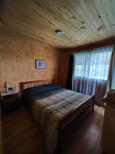 a bedroom with a large bed in a room with a window at Cabañas del real in San Fabián de Alico