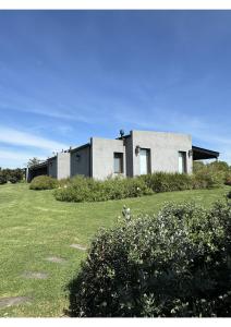 a house sitting on top of a lush green field at Casa de Campo Familiar in Lobos