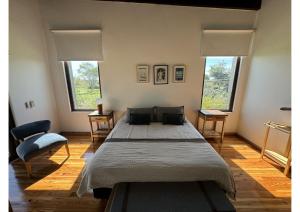 a bedroom with a large bed and two windows at Casa de Campo Familiar in Lobos +19 photos