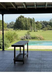 a wooden bench sitting on a patio next to a pool at Casa de Campo Familiar in Lobos