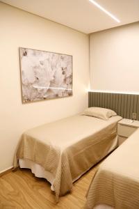 En eller flere senge i et værelse på Moderno ao lado do Shopping