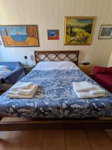 Una cama con edredón azul y toallas. en Artist's House Colosseum, en Roma