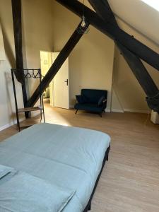 a bedroom with a bed and a chair in a attic at Appartement cosy gare chateaucreux in Saint-Étienne