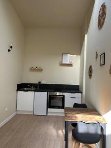 a kitchen with a table and a counter top at Appartement cosy gare chateaucreux in Saint-Étienne