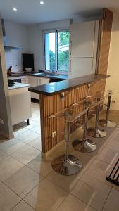 a kitchen with a bar with stools around it at Les hauts château in Chalifert