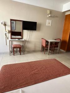 a living room with a table and chairs and a mirror at Ellis Hotel Apartments in Larnaca