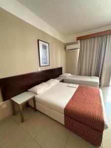 a hotel room with two beds and a window at Ellis Hotel Apartments in Larnaca