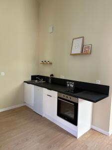 a kitchen with a black counter top and a sink at Appartement 2 chambres gare chateaucreux in Saint-Étienne