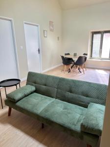 a living room with a green couch and a table at Appartement 2 chambres gare chateaucreux in Saint-Étienne