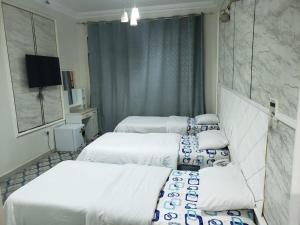 a hotel room with three beds and a television at marhaba hotel in Dubai +10 photos