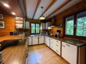 a large kitchen with white cabinets and wooden floors at De Goudvink in Les Flachis