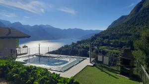 a house with a swimming pool and a view of a lake at Il Giardino vista lago in Fonteno
