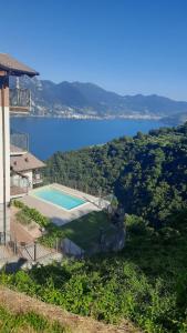 a house with a swimming pool next to a lake at Il Giardino vista lago in Fonteno