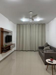 a living room with a couch and a television at Residence Villa Vignoli in Arraial do Cabo