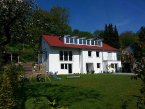 uma casa branca com um telhado vermelho e um parque infantil em Teck-Apartment em Kirchheim unter Teck