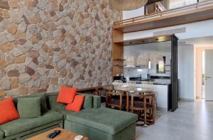 a living room with a green couch and a stone wall at Luxury Stays in Ancient Sands, El Gouna in Hurghada