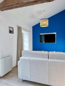 een woonkamer met een bank en een blauwe muur bij #LeBlue #Centre Ville in Cognac