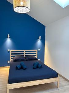 een blauwe slaapkamer met een bed met twee blauwe kussens bij #LeBlue #Centre Ville in Cognac