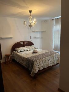 una camera da letto con un letto e un lampadario di Suíte e Quartos Privativos em frente a praia de Copacabana, Rio de Janeiro a Rio de Janeiro