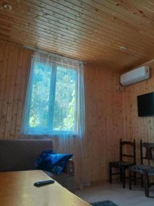 a room with a window and a couch and a table at family hostel in K'veda Bzubzu