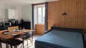a bedroom with a bed and a table with chairs at Appartement spacieux in Frasne