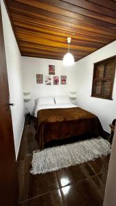 a bedroom with a large bed with a wooden ceiling at Village Arcoverde - Visconde de Mauá in Bocaina de Minas