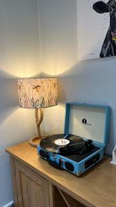 a table with a cd and a lamp and a record player at Swallow Cottage in Ripon