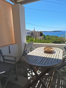 Ein Tisch und Stühle auf einem Balkon mit Meerblick in der Unterkunft Kelly's in Chrissi Akti