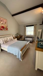 a bedroom with a bed and a desk and a window at Swallow Cottage in Ripon