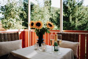 a table with glasses and a vase with sunflowers on it at Ferienwohnung Goldtann in Elzach