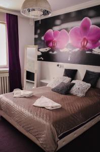 a bedroom with a large bed with pink flowers on the wall at Vladana DELUXE App 2 in Kruševac