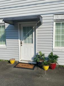 a house with a door and two plants in front of it at Perfect in Pilot Mtn-Unit 1 Walk to Downtown! in Pilot Mountain