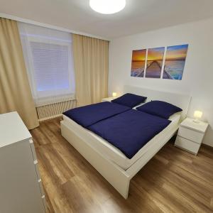 a bedroom with a large bed with blue sheets and blue pillows at House with garden near Vienna & airport 