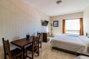 Un dormitorio con una cama, un escritorio y una mesa. en BA Departamentos Microcentro 4, en Buenos Aires