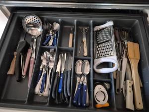 a black tray filled with utensils in a drawer at Maison cozy dans les Volcans in Sayat