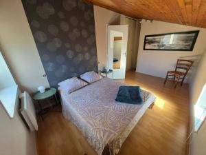 a bedroom with a bed with a blue pillow on it at Maison cozy dans les Volcans in Sayat